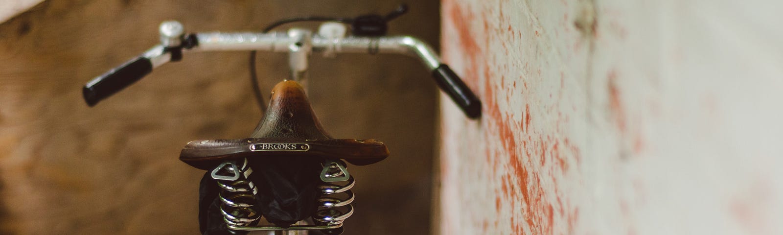 Bicycle with Brooks saddle leaning against a wall