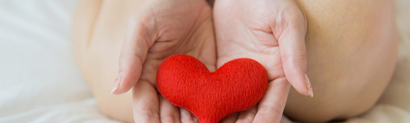 Female hands holding red heart. 3 Ways to let go of resentments.