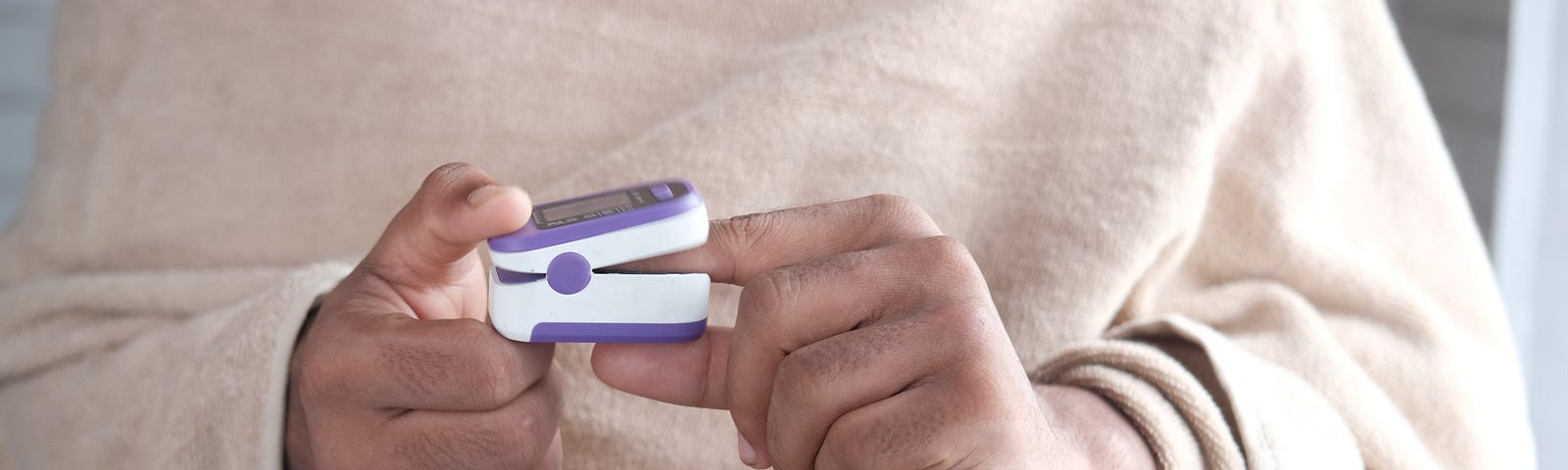 woman checking oxygen level using a pulse oximeter