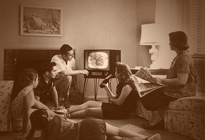 A family of 6 in the late 1950s sitting around the TV.