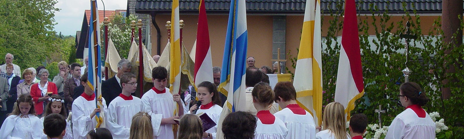 The town folk of Salmuenster (at least the Catholic majority) turn out in bridal white and funeral black to celebrate and acknowledge Blood Sunday near the city square festooned with colorful Church flags and banners.