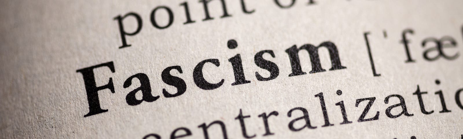 Close up view of a dictionary definition of fascism with the word Fascism capitalized