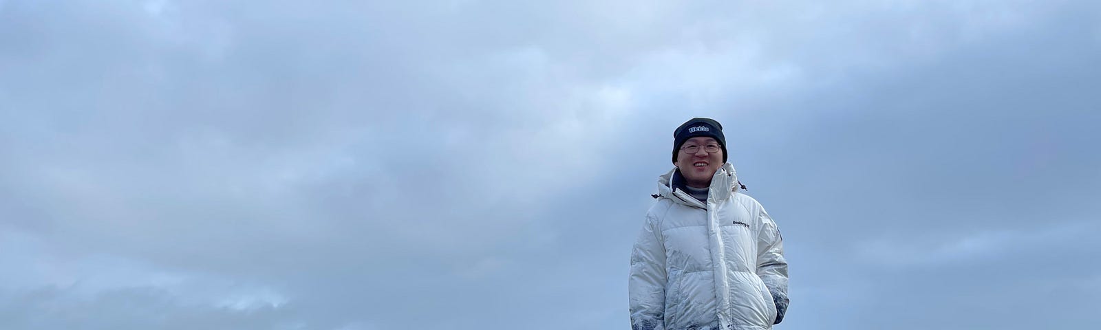 Yang Zhou, the author, is standing beside a rock inscribed with the word “START”.