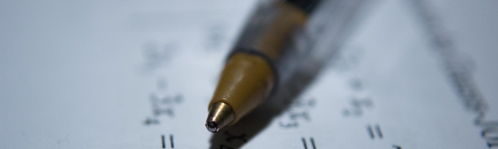 A pen set on top of a worksheet of algebraic equations