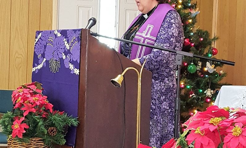 Author Wendi Gordon behind a pulpit preaching at a church