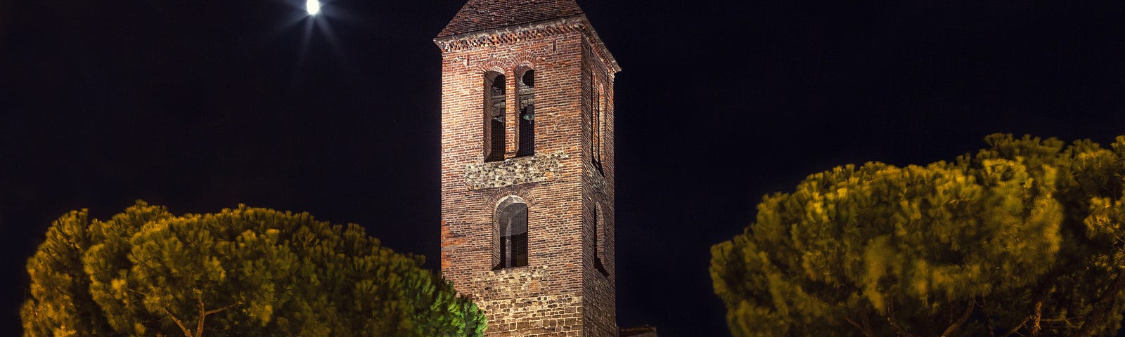 Detailed illustration of a church, with a tower and two trees, under the moonlight at night.