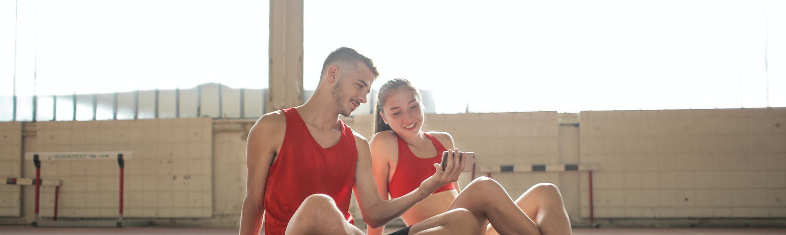 Fit man and woman looking at social media on a mobile phone