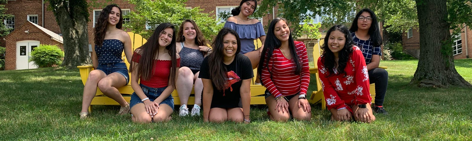 Eight students posing on grass