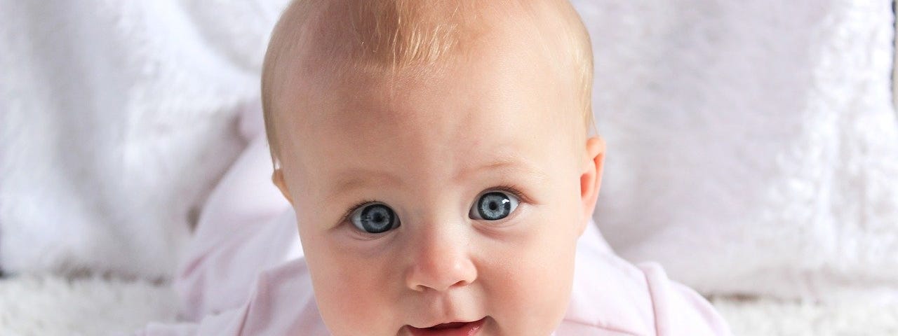 A baby on a white rug