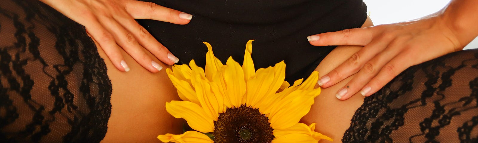 Sunflower in between the legs of a woman dressed in sexy lingerie