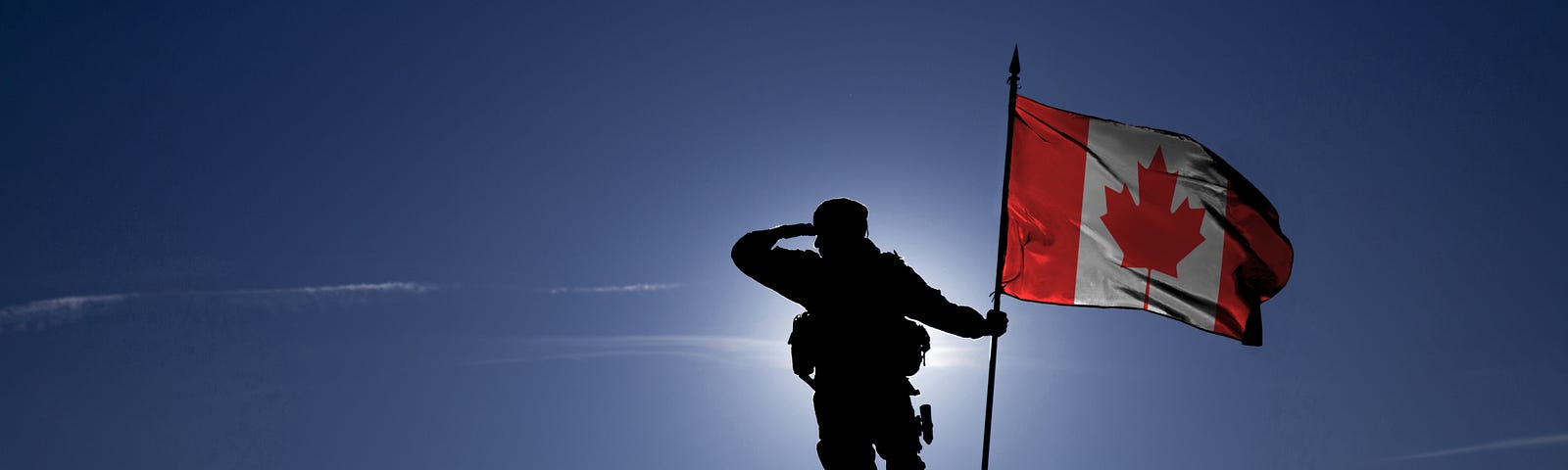 man on mountain with Canadian flag