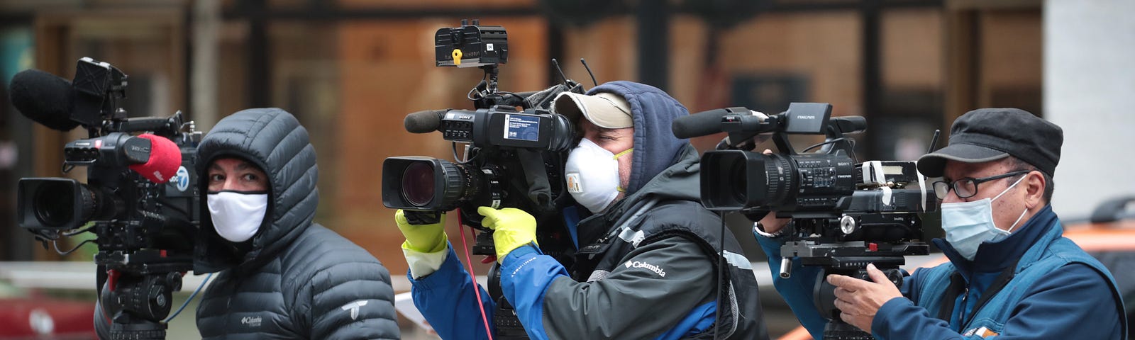 Journalists wearing masks and using cameras to document a protest in Chicago, IL