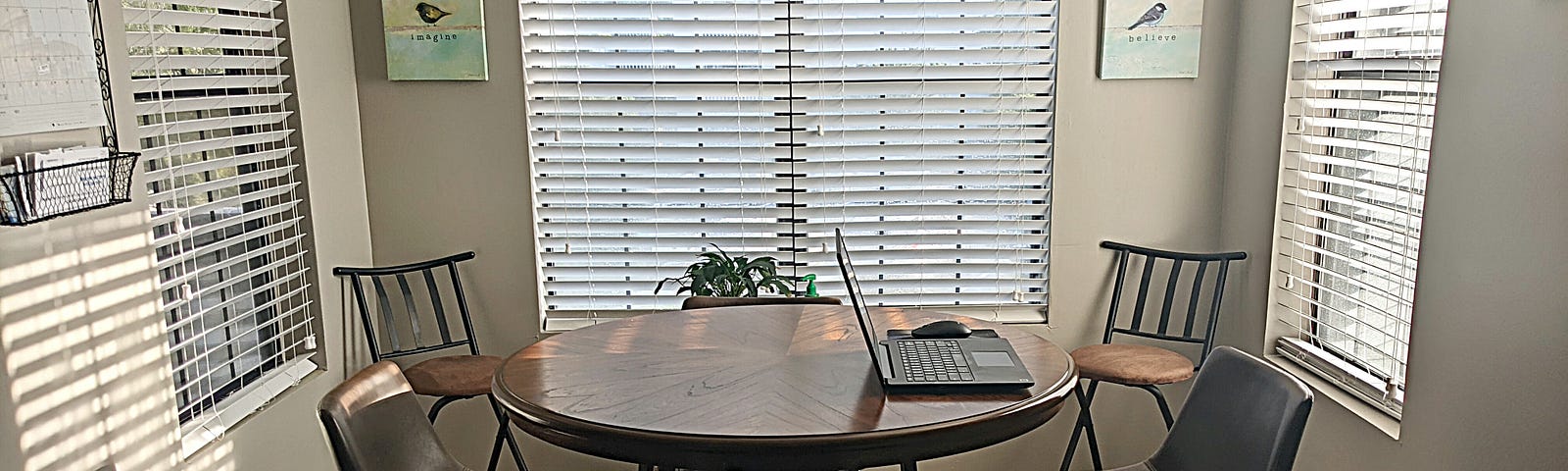 A photograph of my breakfast nook, a beautiful space with plenty of natural light and artwork surrounding me.