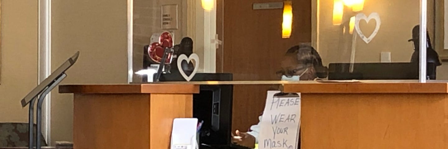 Desk With Nurse and Sign, courtesy of the Author