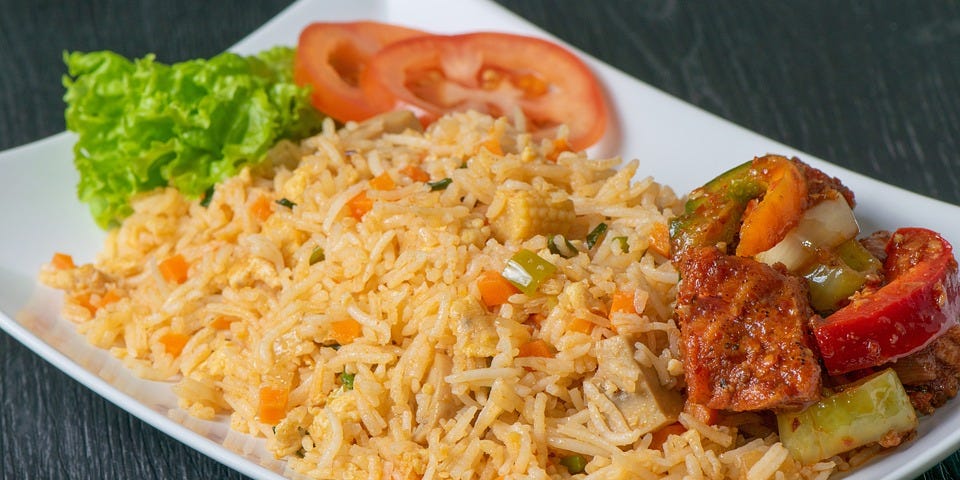 A plate of delicious vegetable rice with a little salad aside.