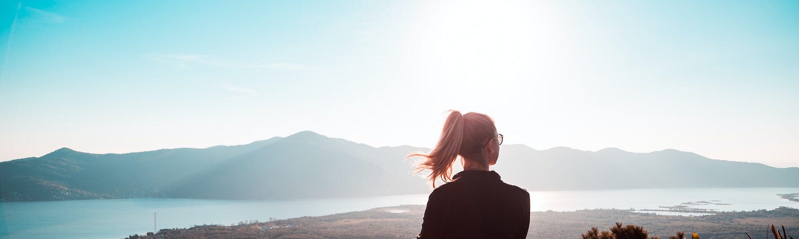 Woman sitting at the edge of mountain