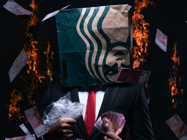 A suited man holds money, the globe, while a Starbucks bag burns on his head