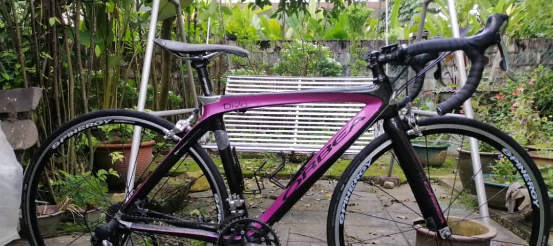 An electric pink Orbea road competition bike.