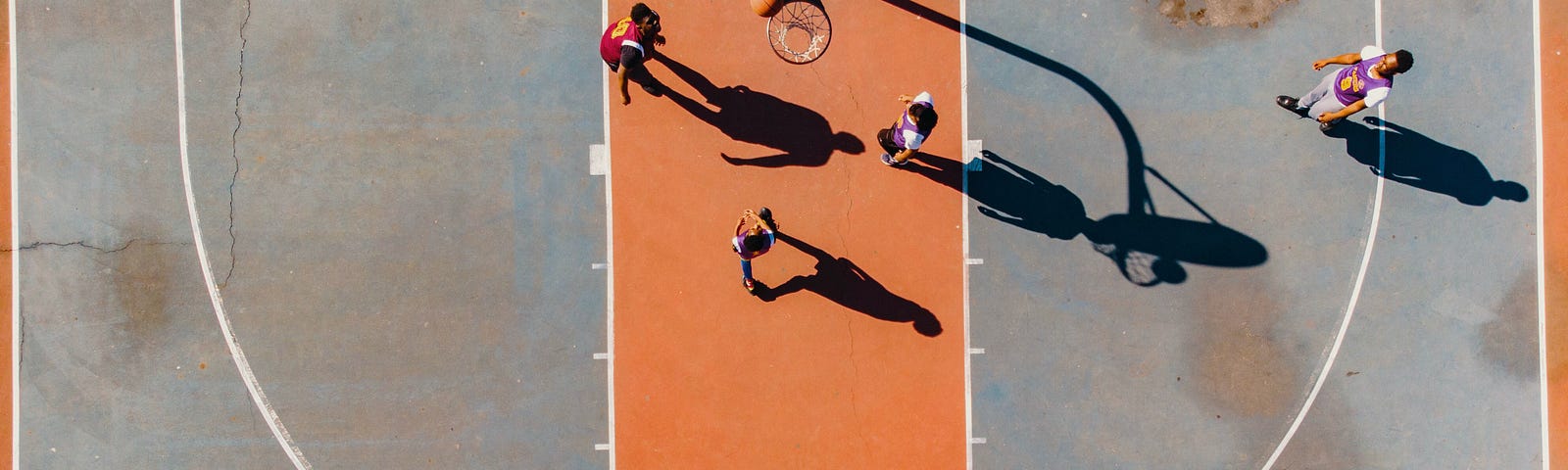 Top-down view of a basketball court with people playing.