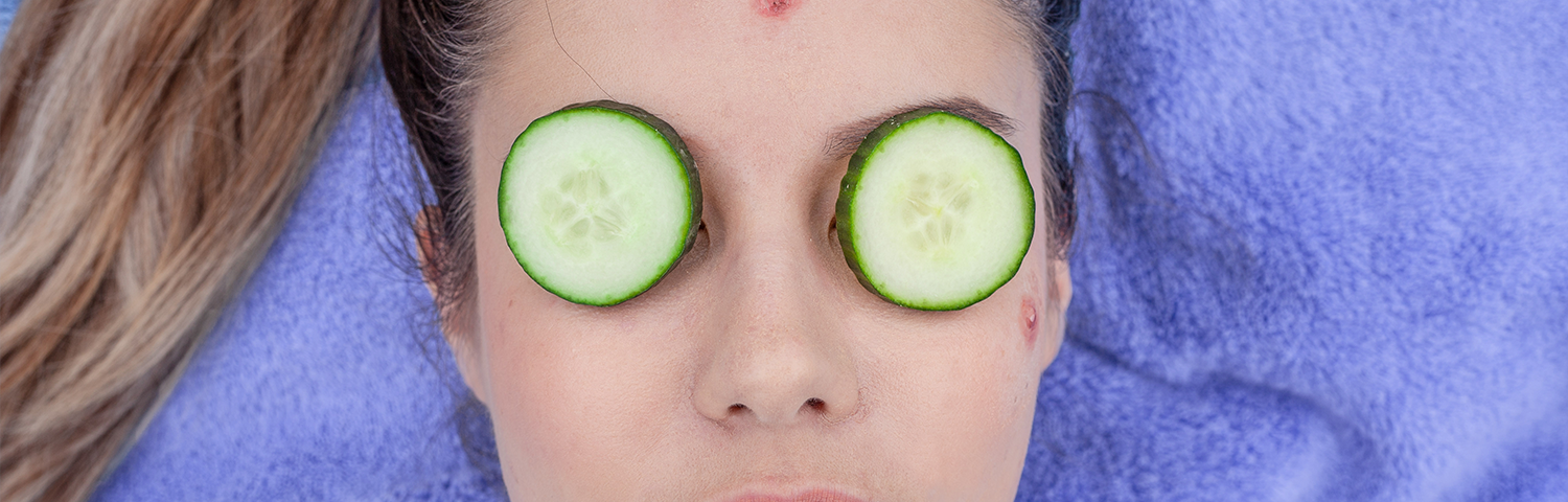 Woman using cucumber slices as a DIY treatment