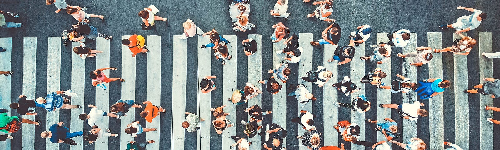 Busy city crosswalk view from above, representing the vulnerabilities large cities face as centralized systems in a pandemic.