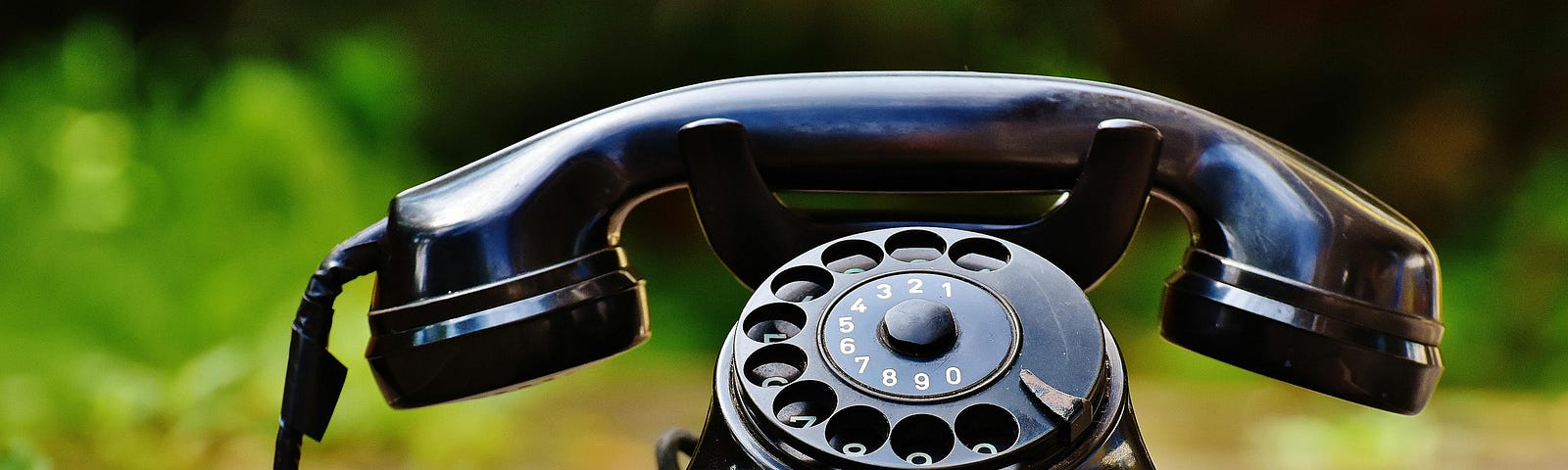 An old-fashioned rotary telephone sitting on a table.