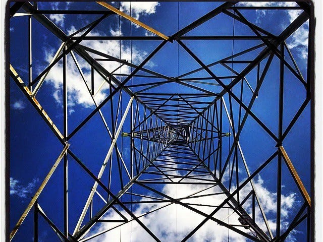 IMAGE: An electricity tower as seen from the ground, on a blue sky with some clouds