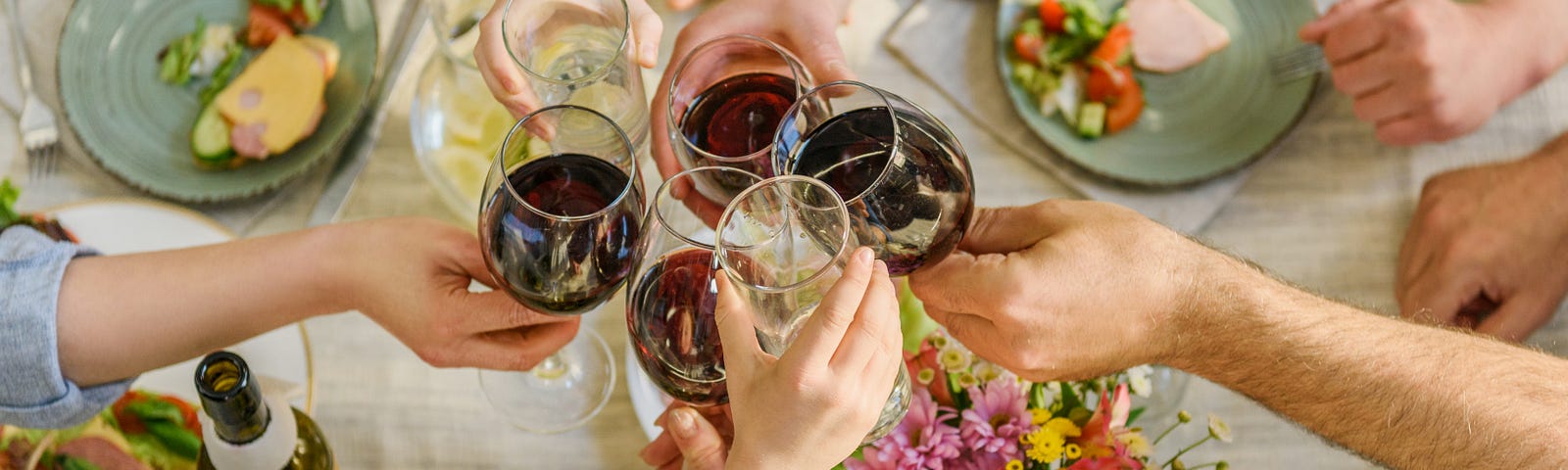 Four glasses of wine over a platter of delicious food