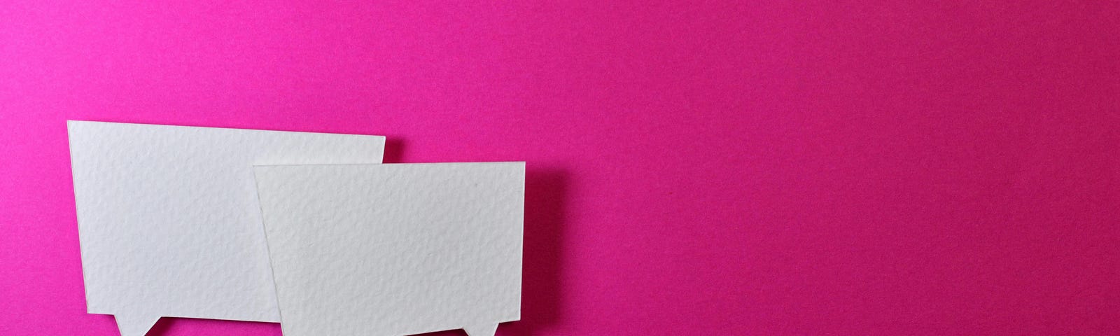 Two square white speech bubbles on a bright pink background.