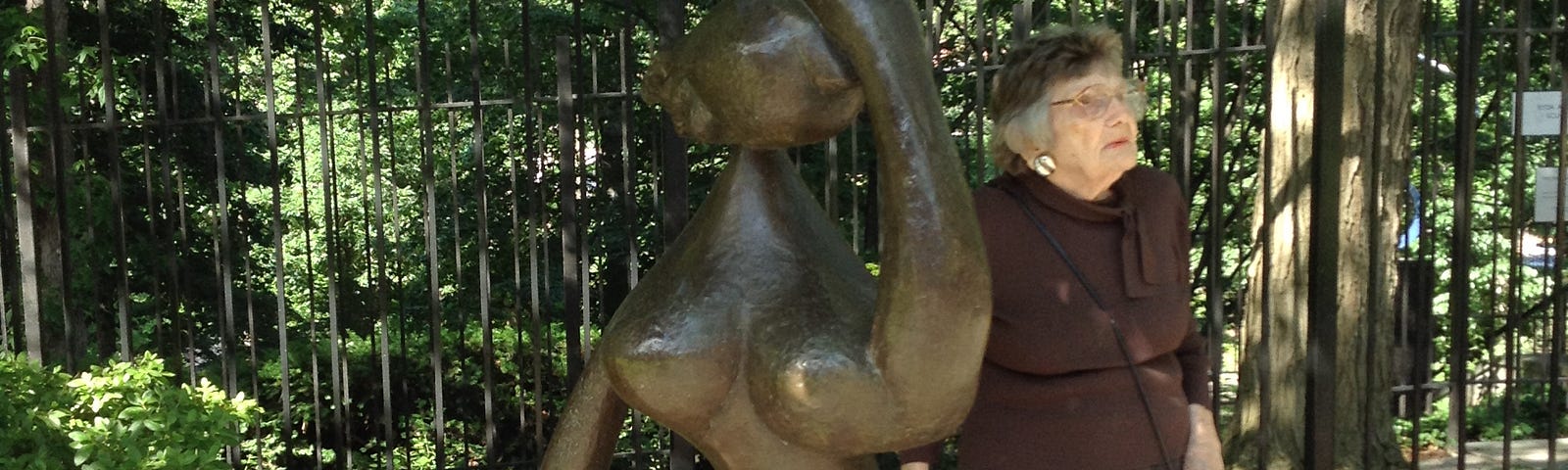 Elderly woman standing next to Henri Lauren outside sculpture at the Baltimore Museum of Art
