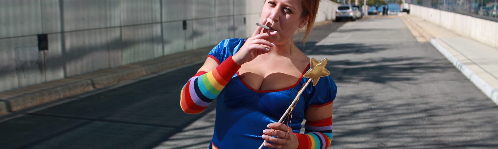 A busty redheaded woman with a fairy costume and a cigarette holds a wand.