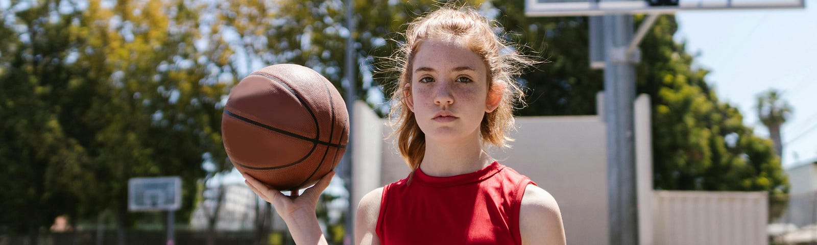 Girl with basketball in driveway.