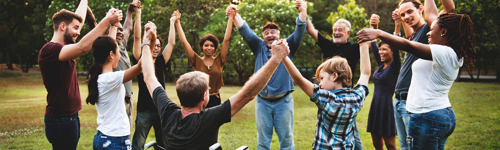 People of all ages holding hands in a circle outside
