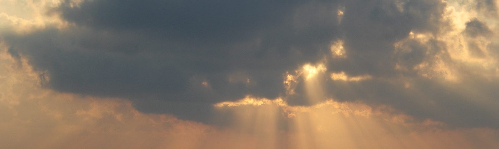 Light piercing through the clouds and down at the ocean. A divine moment in time.