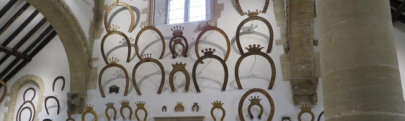 Oakham Castle, Rutland, England. A side wall full of horseshoe tributes.