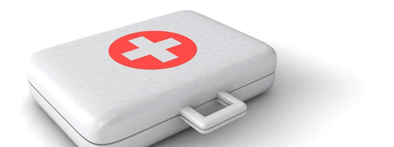 IMAGE: A first aid kit on white with a red cross on top