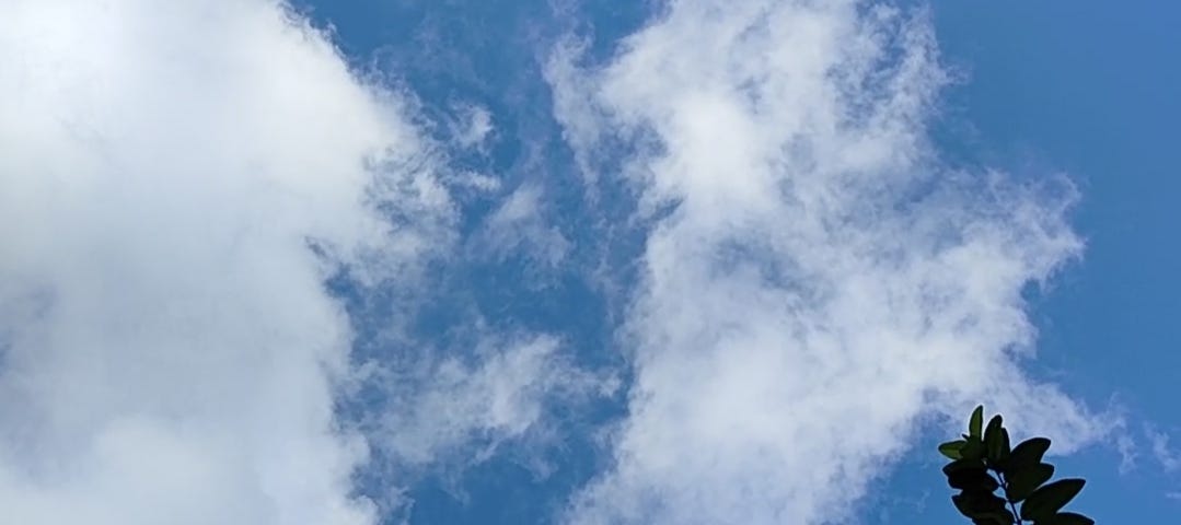 A photo of the cast blue sky, with white clouds