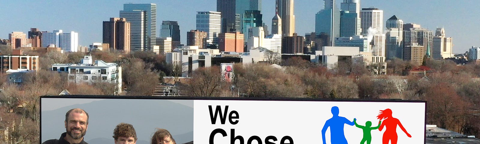 Billboard on Minneapolis skyline, with photo of 2 parents child on hike, happy, with headline, We Chose One!