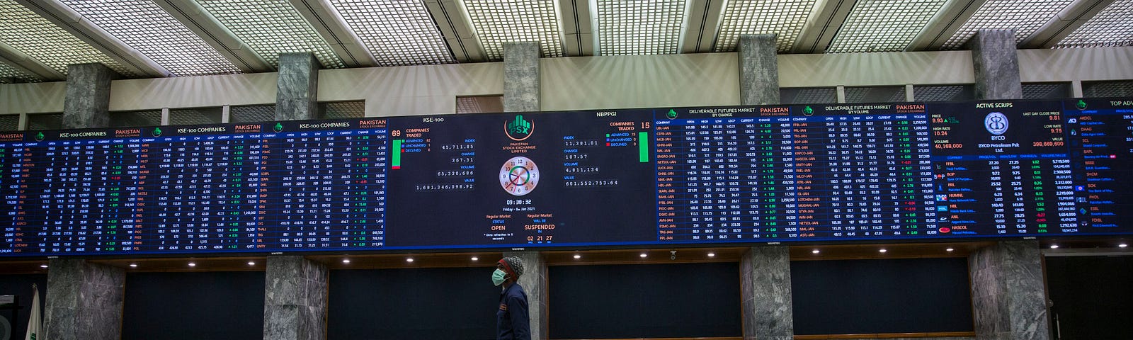 A staff member wearing a face mask walks through the empty main hall of the Pakistan stock exchange.