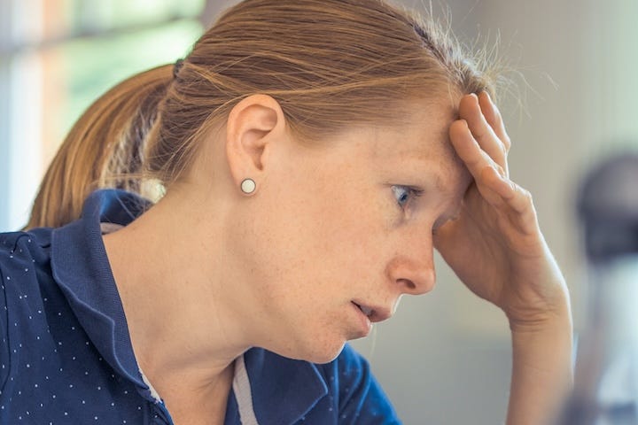 Stressed out female employee with head in hands