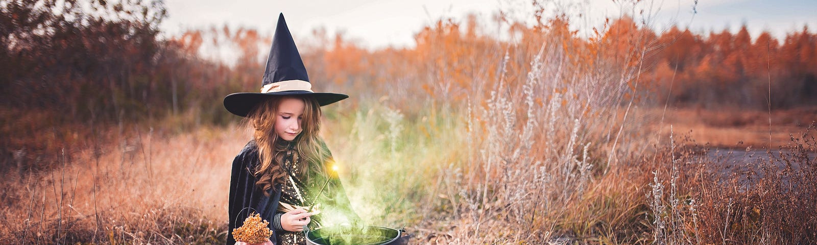 A young witch stands over her cauldron