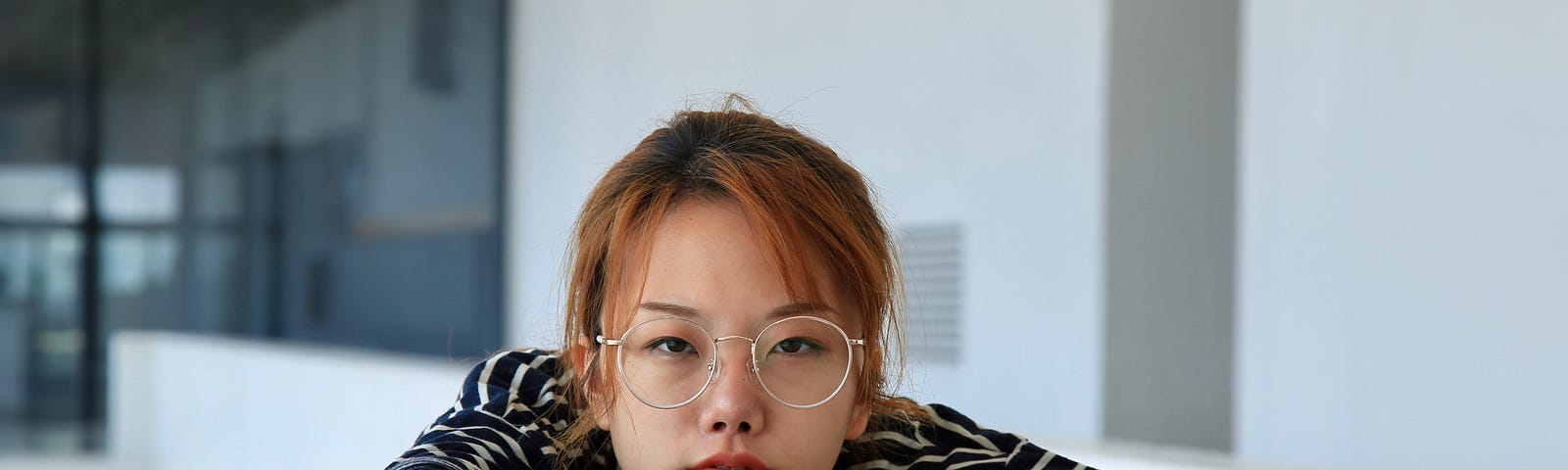 A young woman with eye glasses making a bold face and stare