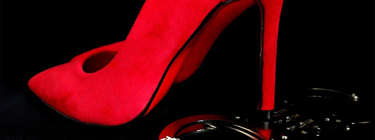 Red high-heeled shoe and silver handcuffs