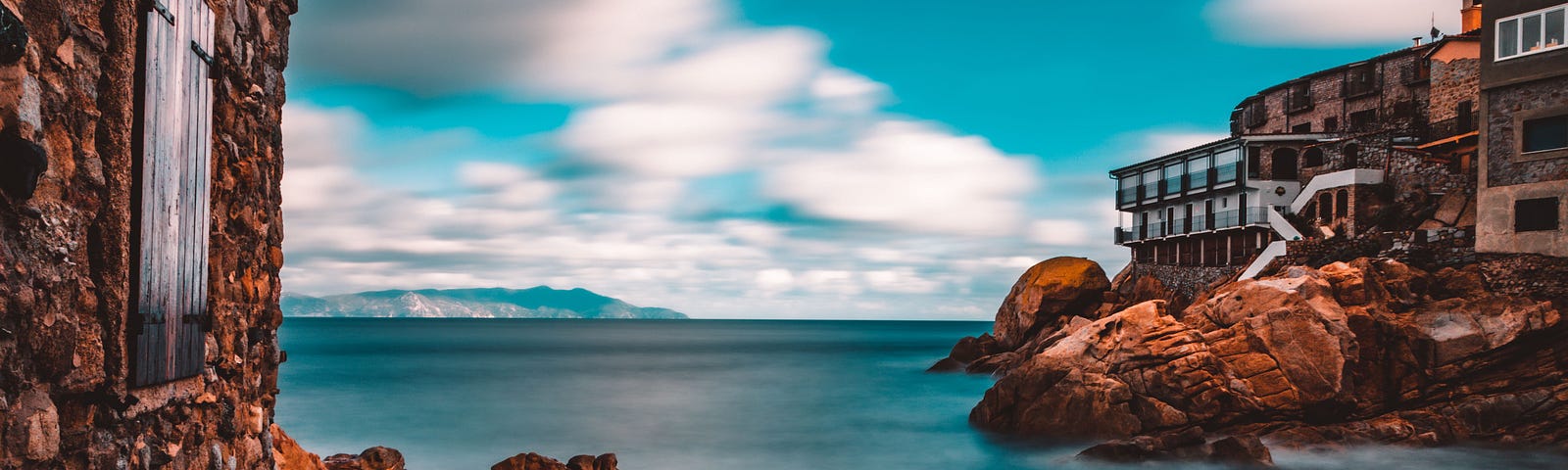 Buildings made from stone overlooking the ocean.