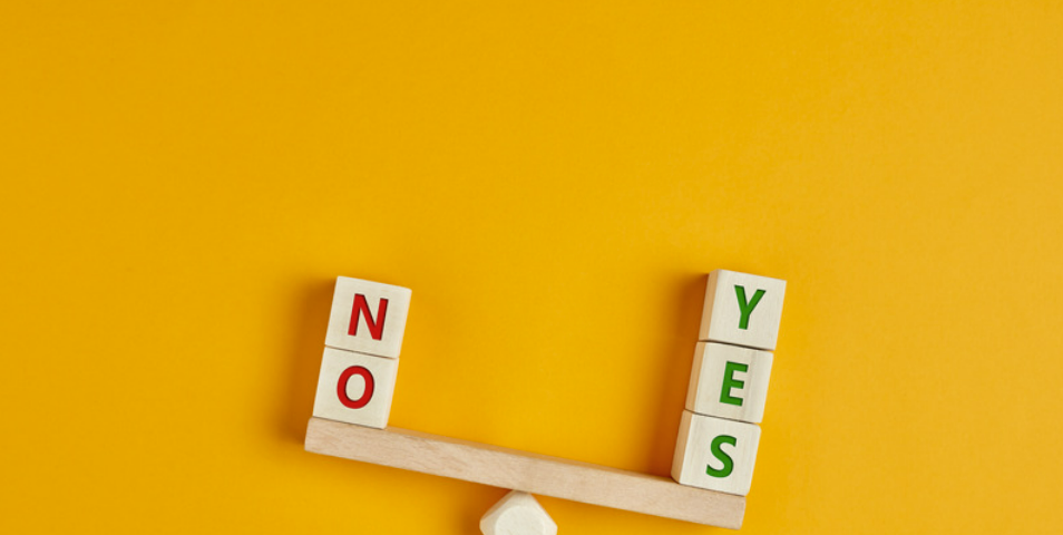 Decision between Yes or No on a wooden scale with orange background