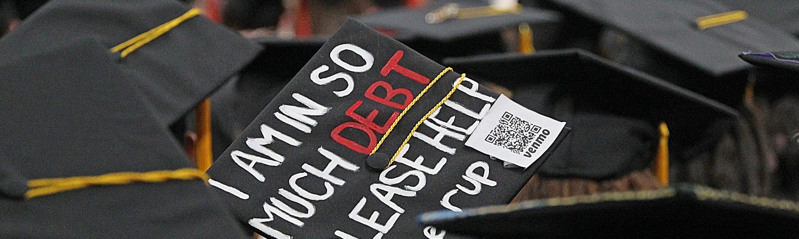 A graduation cap that says “I am in so much debt please help.”