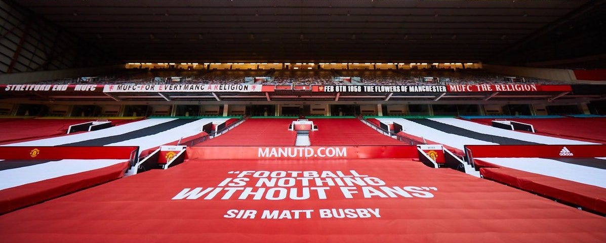 Old Trafford banner reading “Football is nothing without fans” — Sir Matt Busby