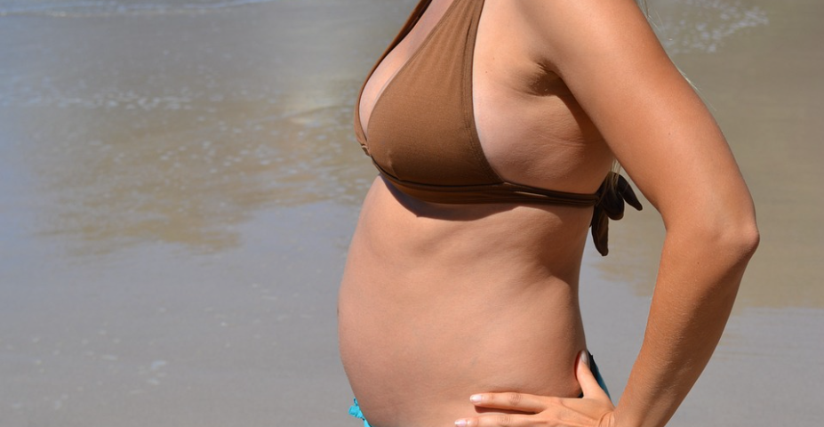 Pregnant woman by a lake.