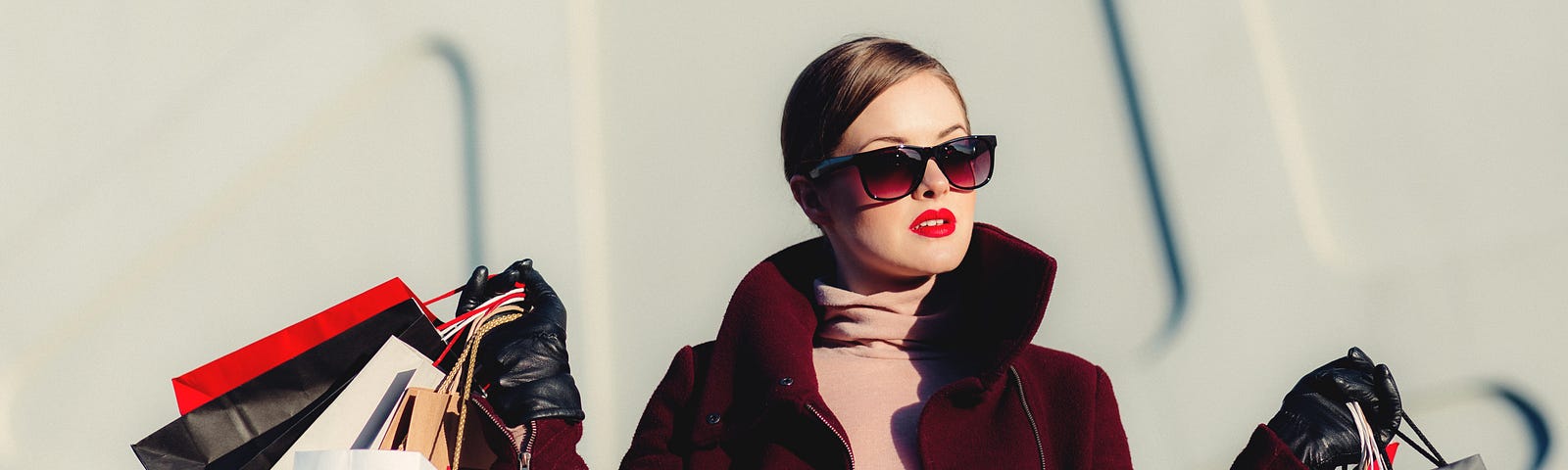 Woman wearing sunglasses and carrying shopping bags