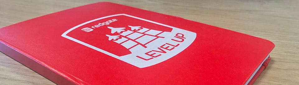 Front cover of a red notebook, with the ‘Redgate Level Up’ logo on it